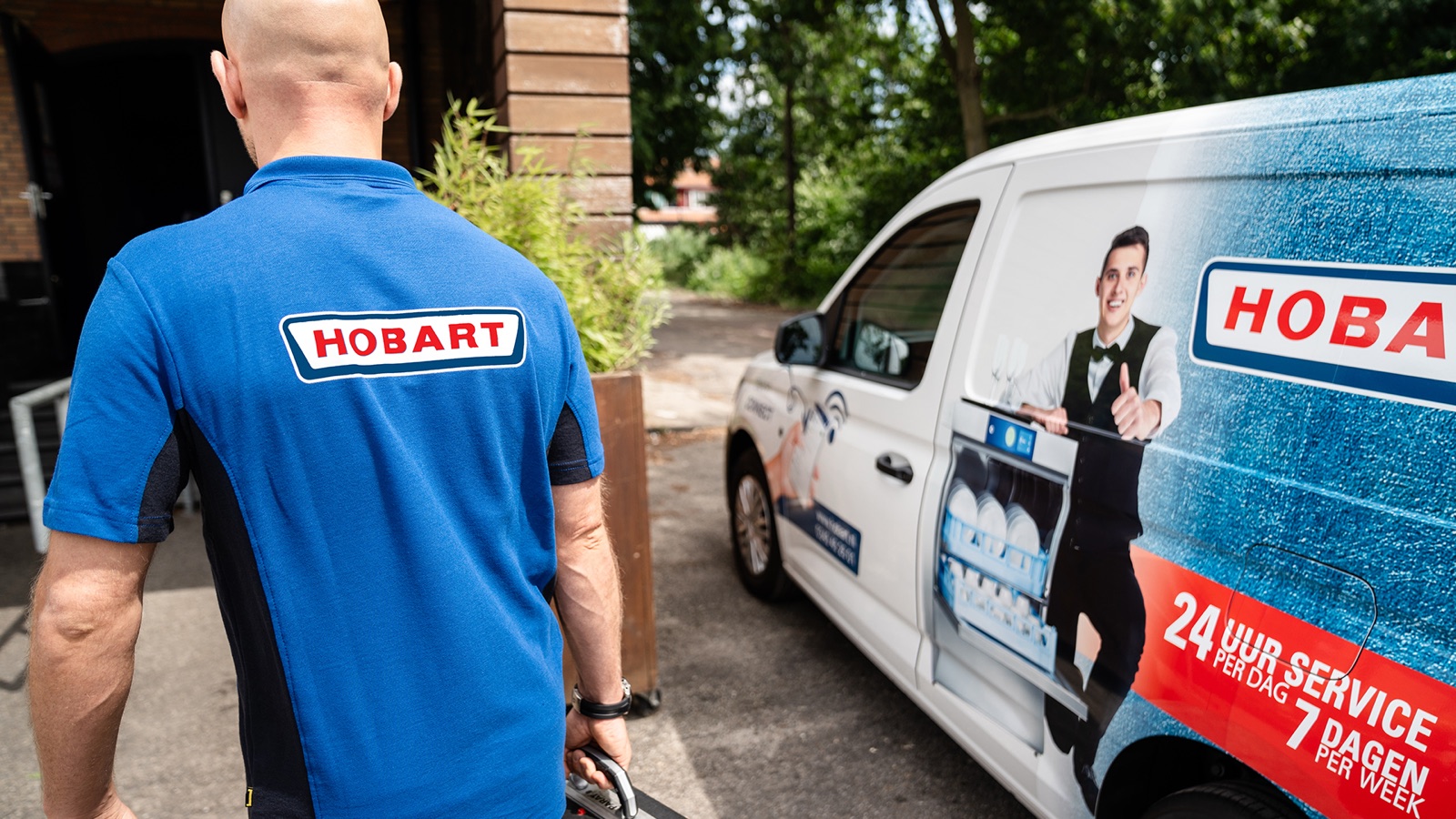 HOBART servicemonteur loopt met gereedschapskoffer naar de servicebus met 24-uursservice